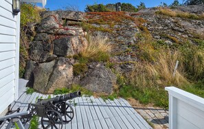 A wooden deck with a cannon and a stone wall. - 3 bedroom nice home in Skjærhalden (Skjærhalden)