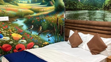 Ein Schlafzimmer mit einer Landschaftsmalerei an der Wand, einem Bett mit weißer Bettwäsche und braunen Kissen sowie einem Holz-Kopfstück.
