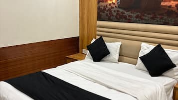 Ein Hotelzimmer mit einem Bett, einer Wand-Klimaanlage und einem großen, gerahmten Kunstwerk.