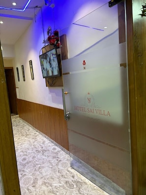A hotel entrance with a frosted glass door, a security camera, and a sign reading 'HOTEL SAI VILLA'. - Hotel Sai Villa (Ahmedabad Gujarat)