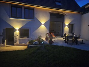A house with a patio area, outdoor seating, and a sliding glass door. - Serrioux House - 4 bedrooms - Sleeps 9–10 - Matheysine - 30 minutes from Grenoble (Cholonge)
