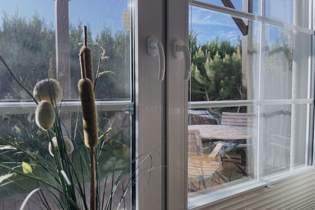 Una ventana con vistas a un patio, que incluye una mesa y sillas.