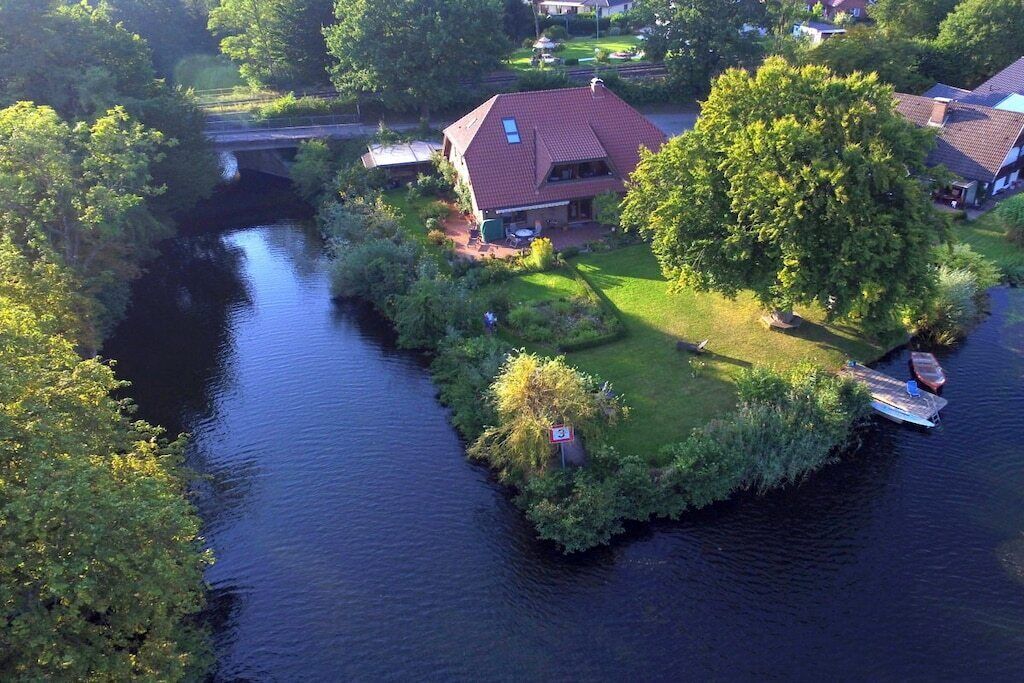 Una propiedad junto al río con una casa, un muelle y un puente.