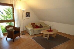 Une pièce confortable avec un canapé, un fauteuil et une petite table.
