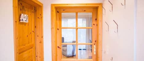Eine Holztür mit einem Fenster, einem Wandhaken und einem Schild mit dem Wort 'BAD'.
