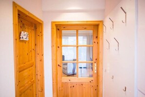 A wooden door with a window, a wall-mounted hook, and a sign with the word 'BAD' on it. - Holiday home with 3 bedrooms (Wurster Nordseeküste)