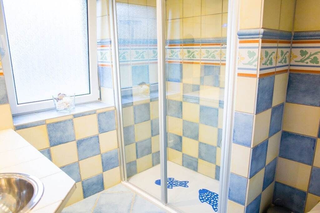 A bathroom with checkered tiles, a window, and a shower area.
