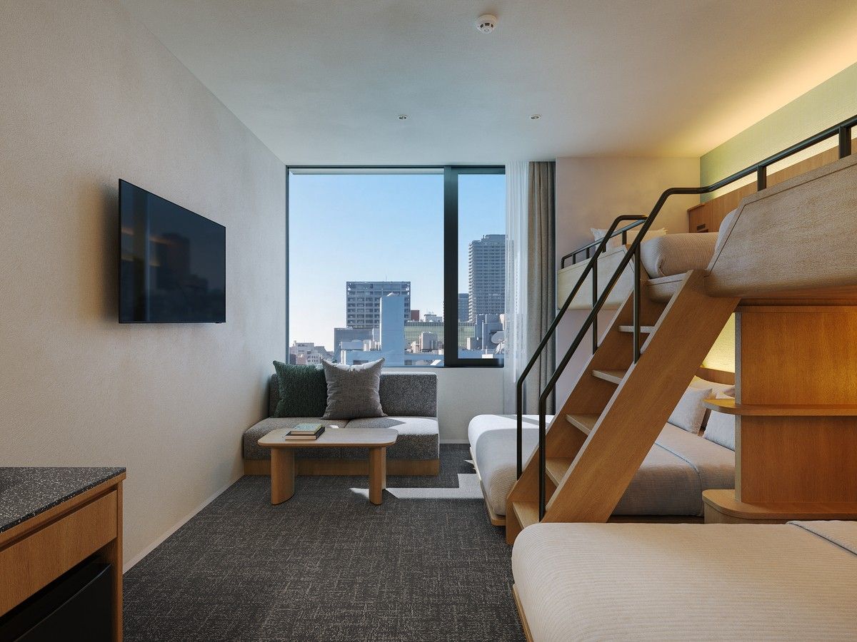Une chambre d’hôtel moderne dotée d’une grande fenêtre, d’un canapé, d’une table basse, d’un téléviseur et d’un escalier.