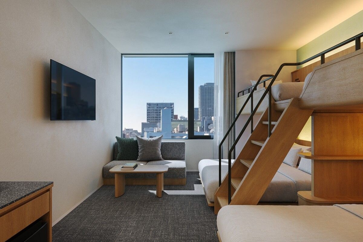 Habitación de hotel moderna con un ventanal grande, un sofá, una mesa de centro, un televisor y una escalera.