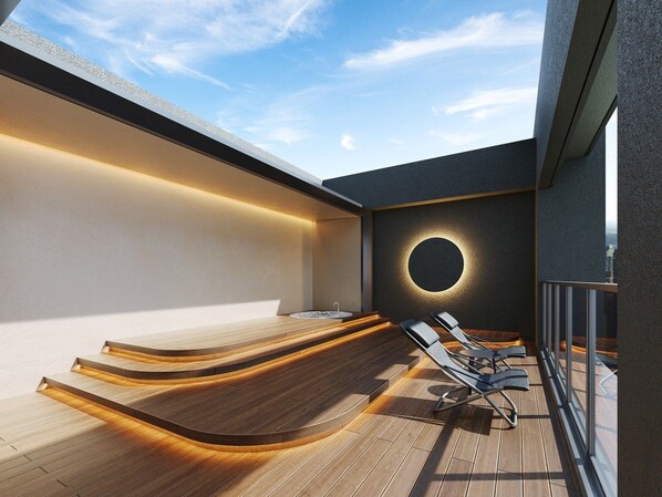 Un bar en la azotea con terraza de madera, un elemento de luz circular y sillones de descanso.