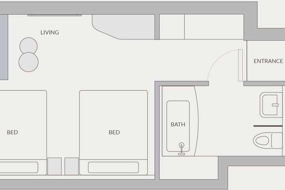Plano de planta que muestra dos dormitorios, una sala de estar, un baño y una entrada.