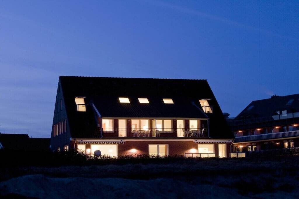 Un immeuble de deux étages doté de nombreuses fenêtres et d’un balcon.