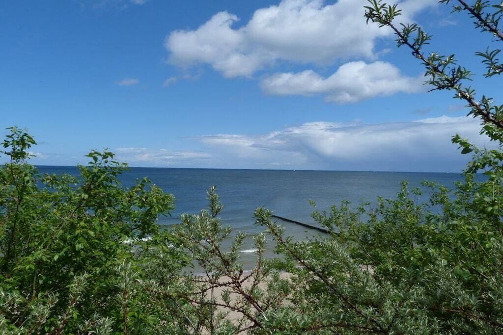 Vista de platja amb cel blau i mar tranquil·la.
