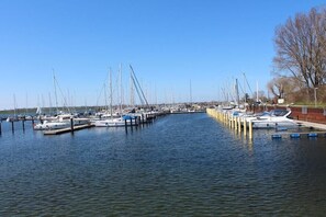 Een jachthaven met meerdere boten afgemeerd bij steigers, kalm water en een heldere lucht.