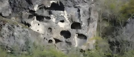 A rocky cliff with multiple caves and openings.