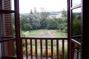 A view from a balcony with a railing, overlooking a garden with various plants and a path. - Detached village house with balcony, near Issoire and natural attractions (Perrier)