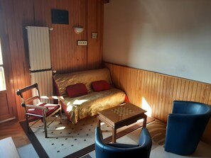 A compact room with a bed, a chair, a small table, and a radiator. - Detached village house with balcony, near Issoire and natural attractions (Perrier)