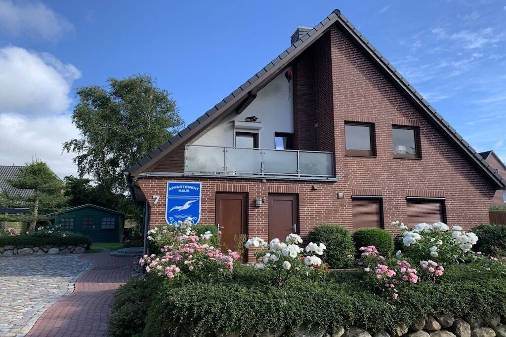 Ein zweistöckiges Gebäude mit einem Schild, das es als Mehrfamilienhaus kennzeichnet.