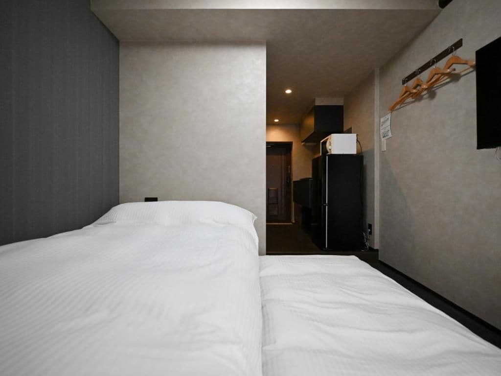 Een hotelkamer met een groot bed, een kast en een klein kitchenette.