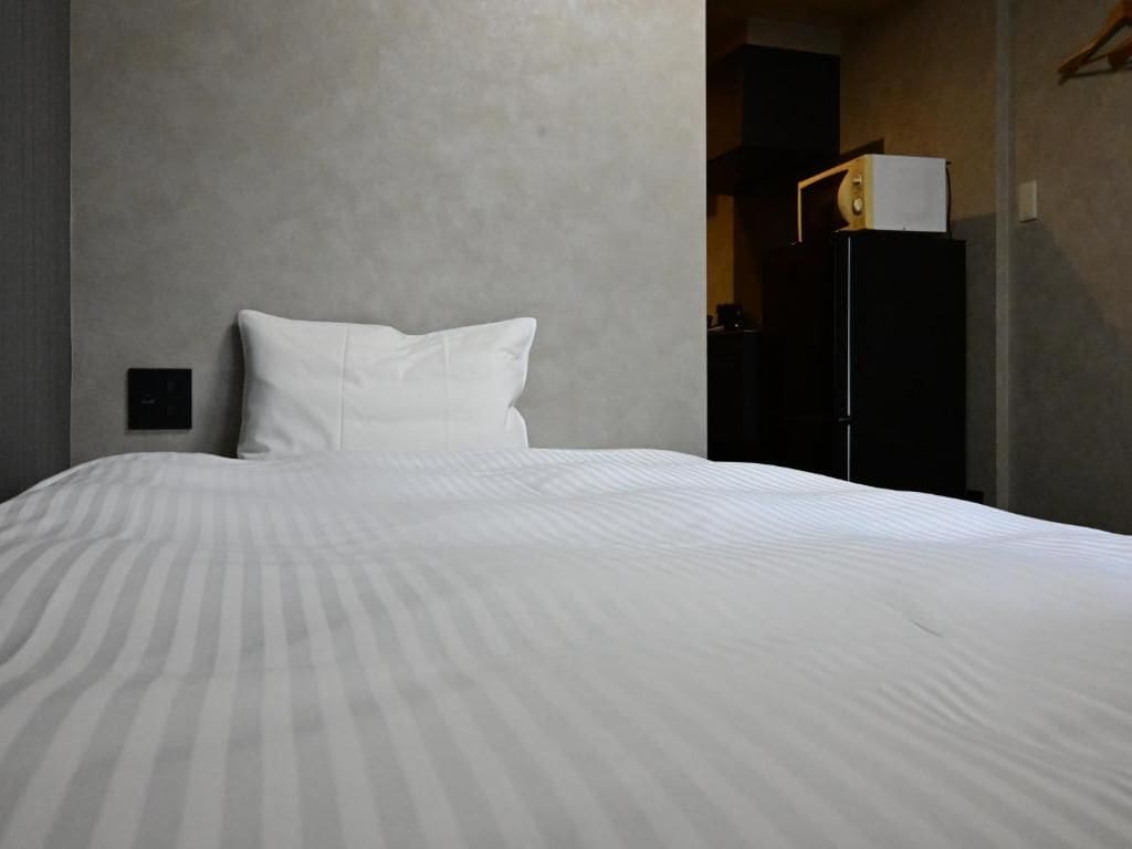 Ein Hotelzimmer mit einem großen Bett, einem Nachttisch und einem Kleiderschrank.
