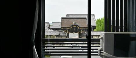 A window view of traditional architecture with a building in the background.