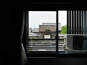 Vista desde la ventana de arquitectura tradicional con un edificio al fondo.