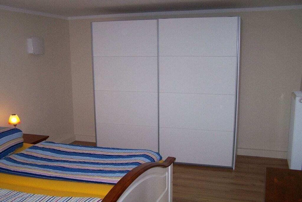Una camera da letto con un letto, una lampada da comodino, un armadio e un tavolino.