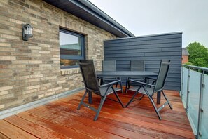 An outdoor patio with a brick wall, a window, and a table with chairs. - Holiday apartment with 2 bedrooms (St. Peter-Ording)