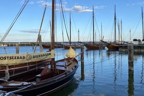 Ein Yachthafen mit mehreren angedockten Booten, im Hintergrund eine Brücke und ein klarer Himmel.