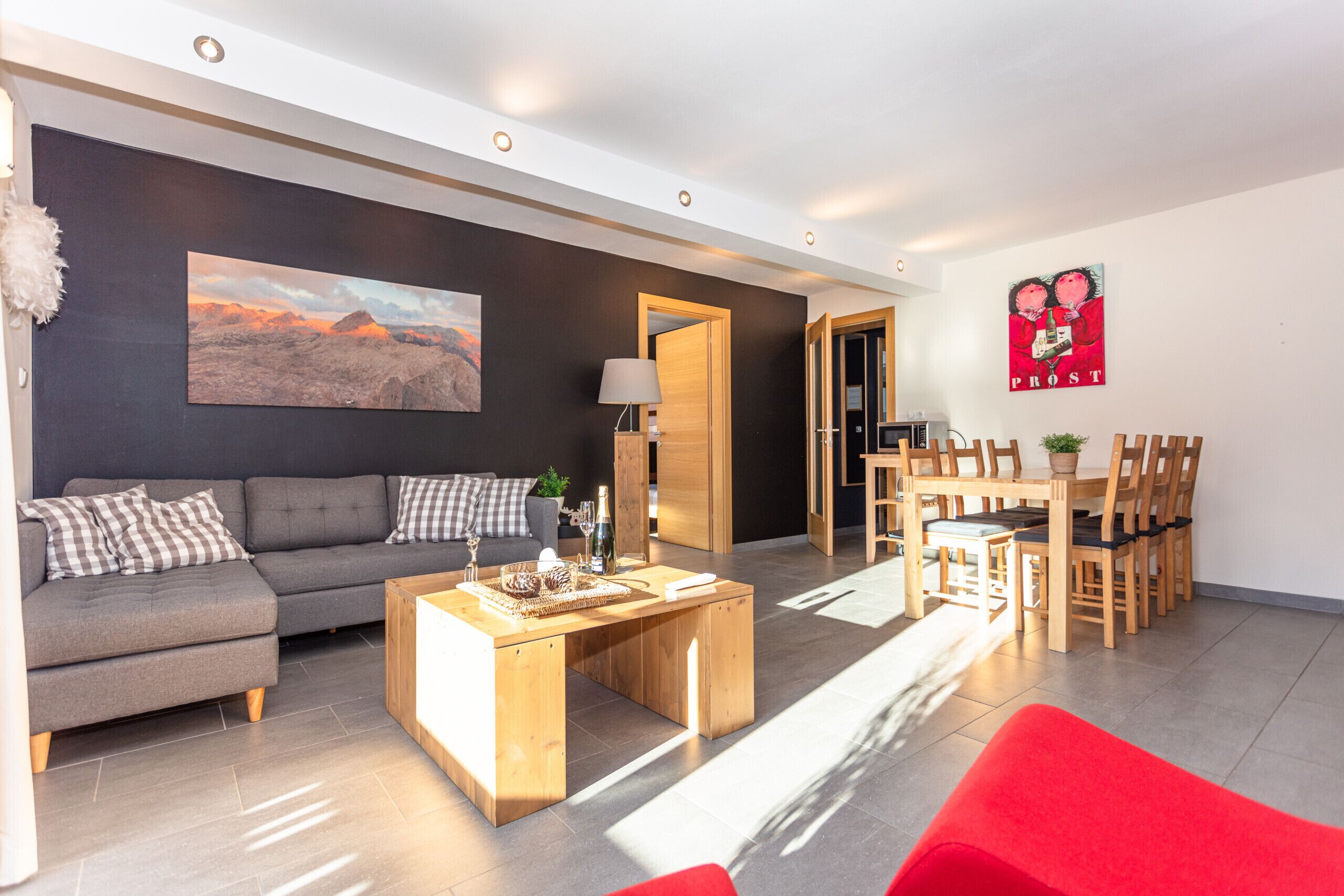 Uma sala de estar moderna com um sofá, mesa de centro e um quadro na parede.