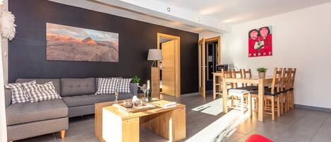 A modern living room with a sofa, coffee table, and a painting on the wall.