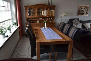 Ein Essbereich mit einem Holztisch, Stühlen, einer Vitrine und einem Bild an der Wand.