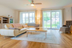 A living room with a sofa, a coffee table, a chair, and a cabinet. - Thatched-roof house Frisian dream (Garding)