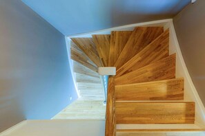 A spiral staircase with wooden steps and a white handrail. - Thatched-roof house Frisian dream (Garding)