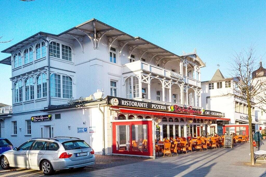 Ein Gebäude mit einem Restaurant namens 'Ristorante Pizzeria' im Erdgeschoss und Außenbereich.