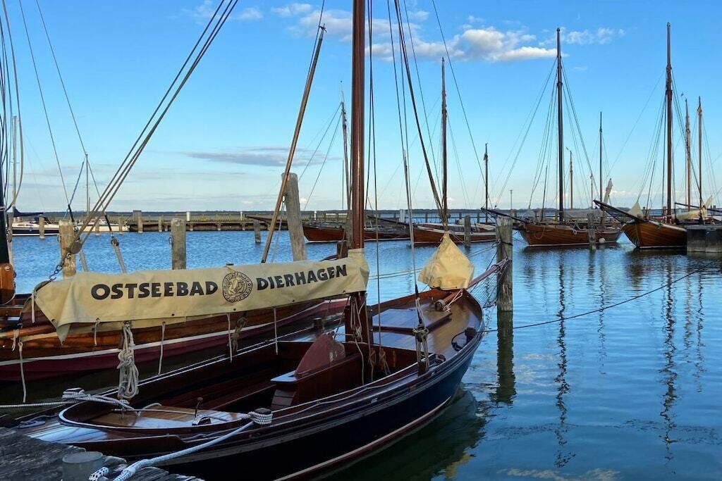 Een rij traditionele houten boten afgemeerd aan een steiger.