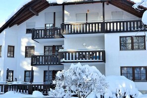 A multi-story building with balconies, windows, and snow-covered surroundings. - House on the Gutach River No. 07 (Titisee- Neustadt)