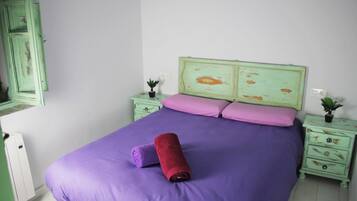 A bedroom with a bed, two nightstands, a dresser, and a mirror.