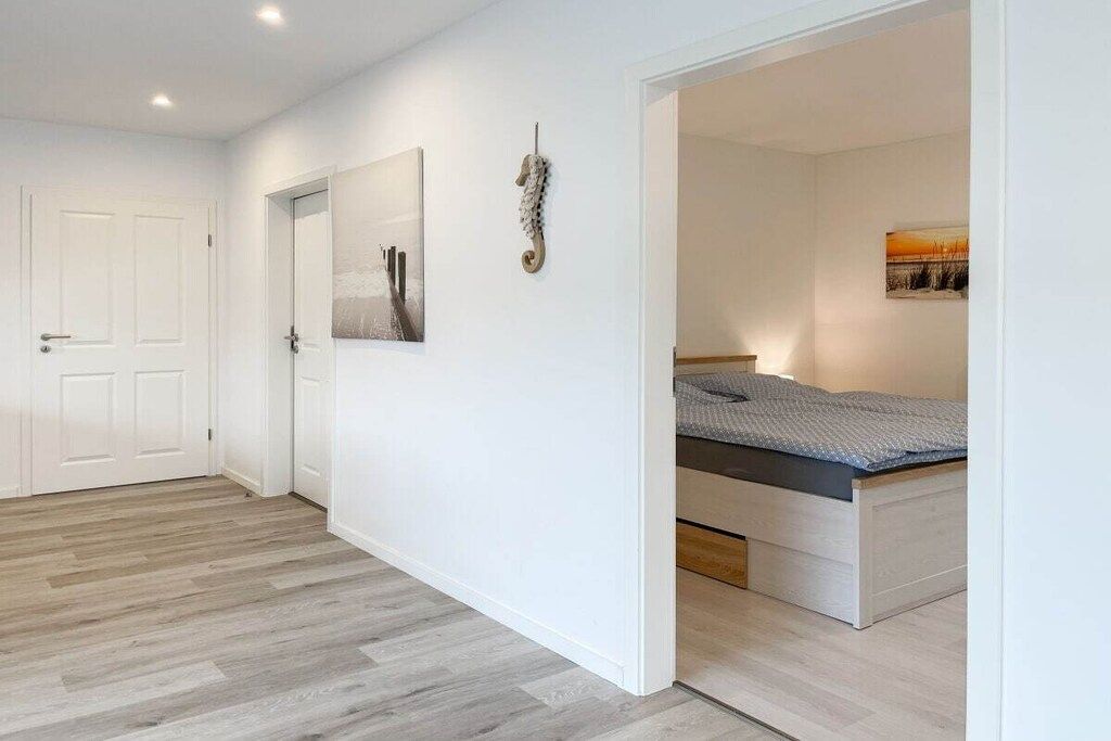Una camera da letto con un letto, una porta e un'opera d'arte appesa al muro.