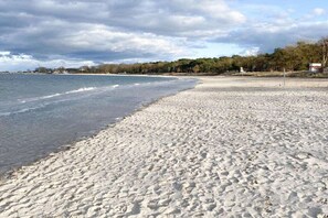 A beach with a wide sandy shore and calm water. - Holiday home with 2 bedrooms (Timmendorfer Strand)