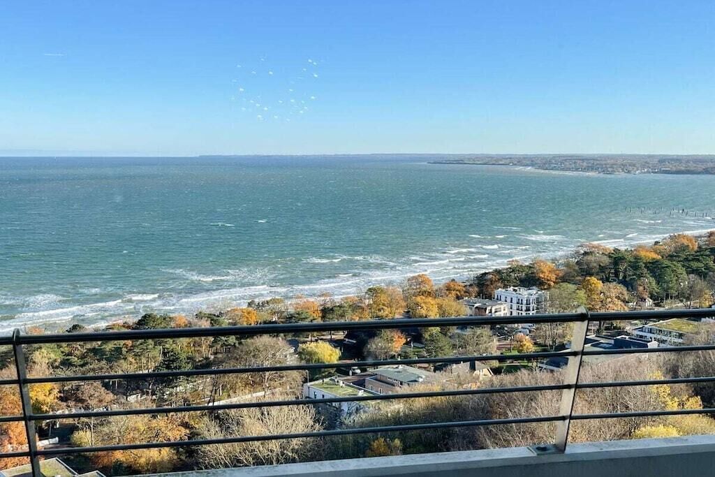 Une vue sur la côte, avec un ciel dégagé, une étendue d’eau et une ligne de rivage lointaine.