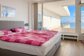 A hotel room with a bed, a window, and a view of the sea. - Holiday apartment with 1 bedroom (Timmendorfer Strand)