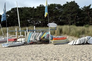 A beach with multiple sailboats and a sign indicating a surf and sail bar. - Holiday apartment in Baabe with swimming pool (Baabe)