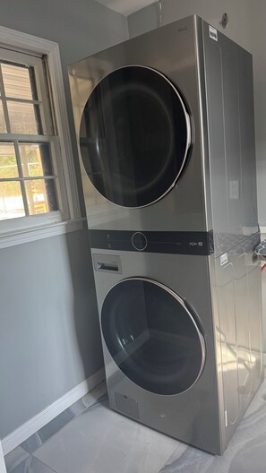 Eine gestapelte Waschmaschine und ein Trockner in einem Raum mit einem Fenster.