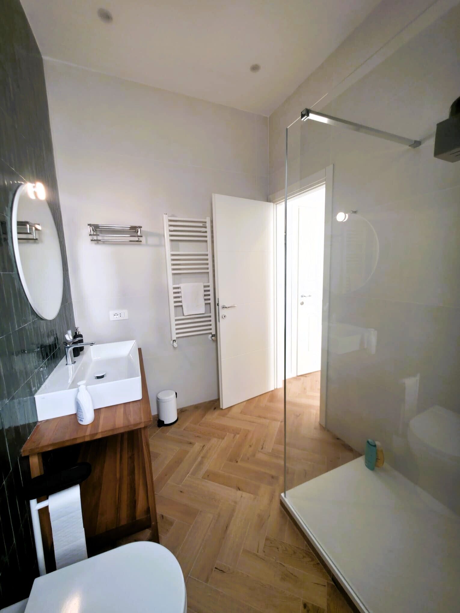 Une salle de bain moderne avec un lavabo blanc, un miroir et des toilettes.