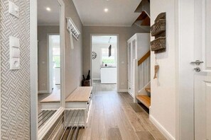 A hallway with a bench, a radiator, and a door leading to a kitchen area. - Holiday home with 3 bedrooms (Timmendorfer Strand)