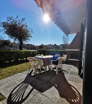 Eine Außenpatio mit Tisch und Stühlen, einer Pergola und Blick auf ein Wohngebiet.