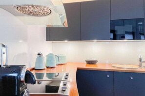 Eine moderne Küche mit integriertem Mikrowellenherd, Toaster und Wasserkocher auf der Arbeitsplatte.