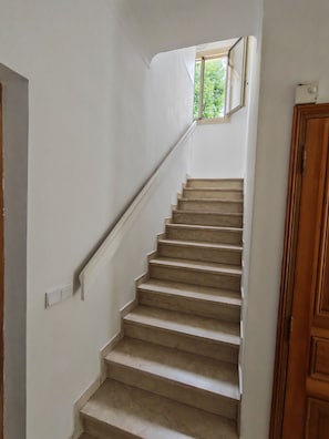 Eine Treppe mit Handlauf, die zu einer Aussichtsplattform mit einem kleinen Fenster führt.