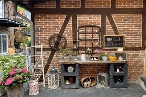 A brick wall with a welcome sign, a wooden wheel, and various decorative items. - Holiday apartment in Waren with swimming pool (Waren)